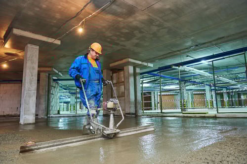 Worker with Concrete Screeder Preparing Floor