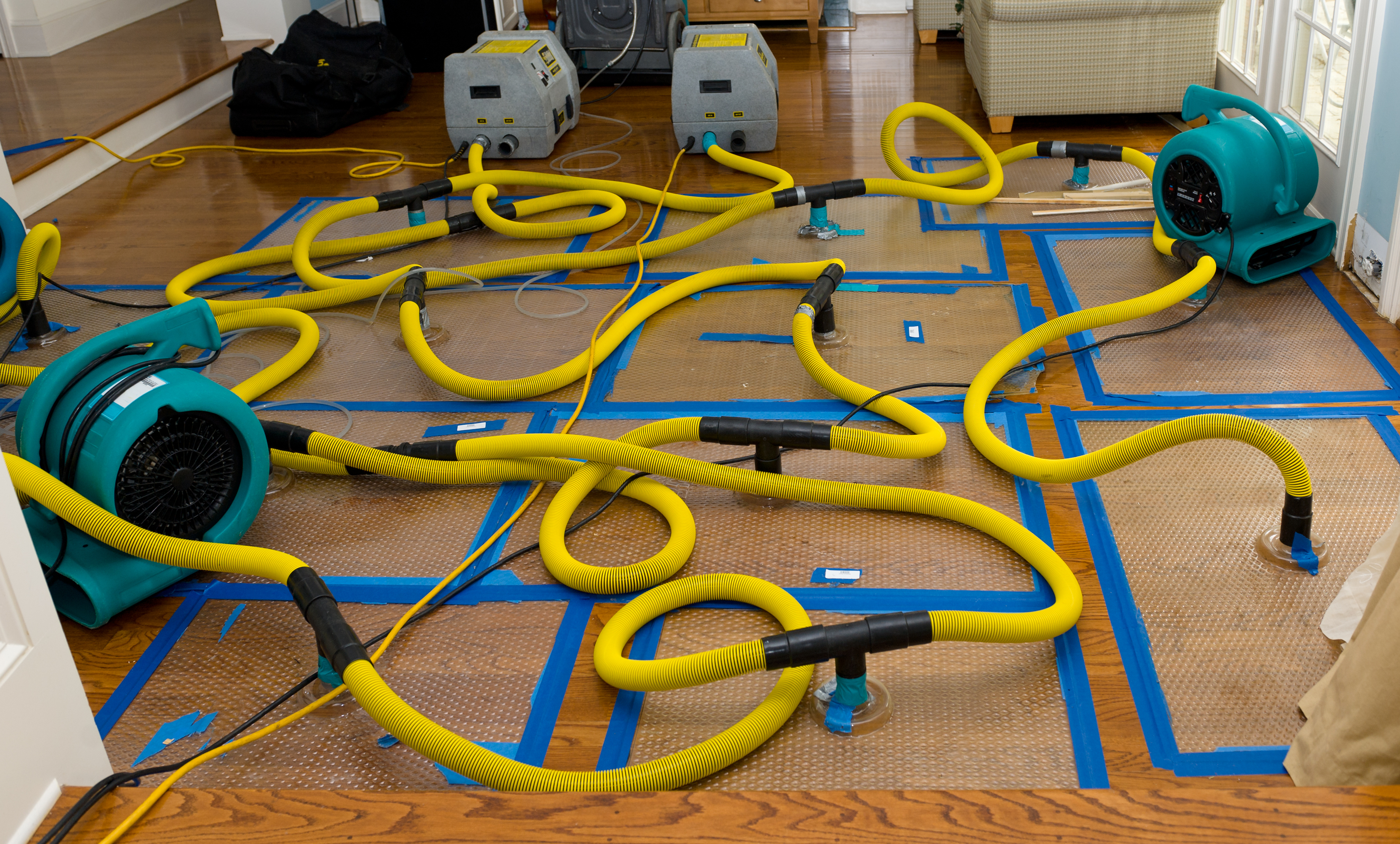 Water mitigation pumps and dryers to suck the water out of a flooded hardwood floor